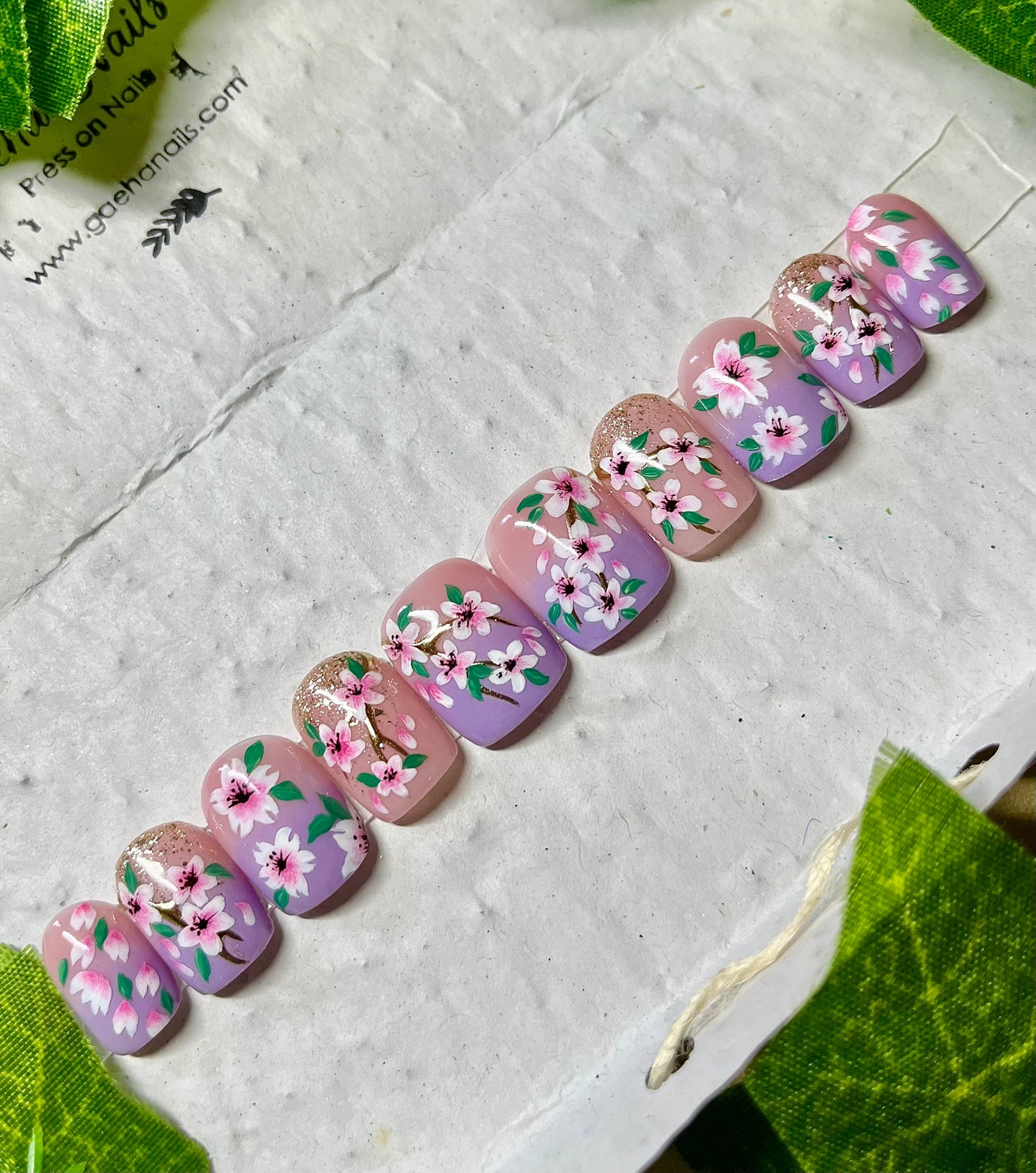 Handgemalte Press On Nägel mit kleinen Kirschblüten auf hellgrünem Hintergrund, wiederverwendbares Nagelset