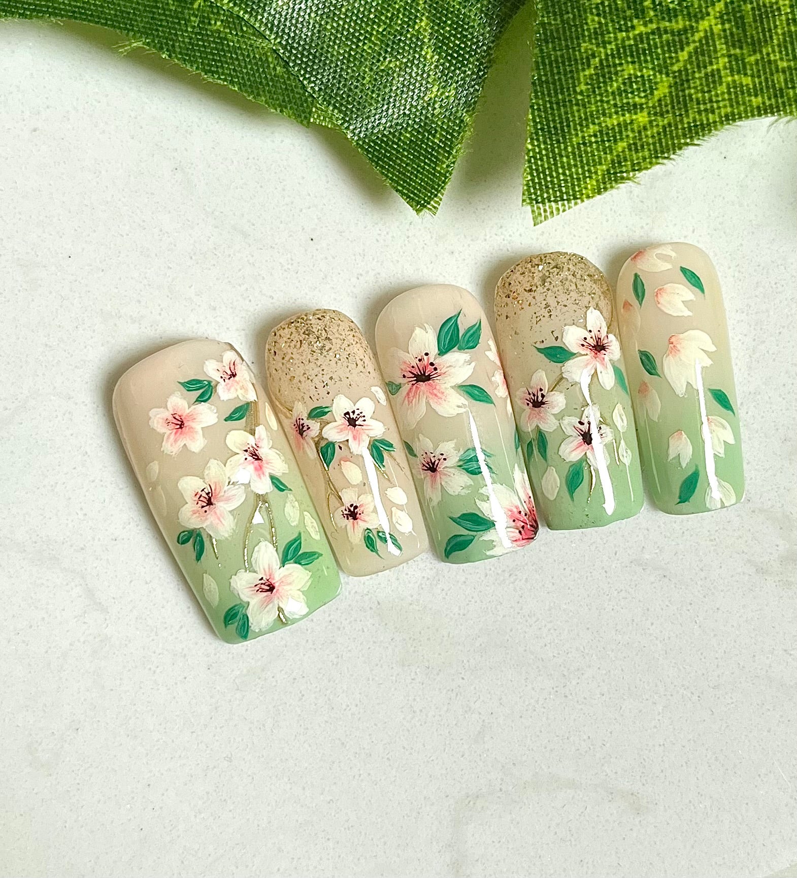 Handgemalte Press On Nägel mit kleinen Kirschblüten auf hellgrünem Hintergrund, wiederverwendbares Nagelset