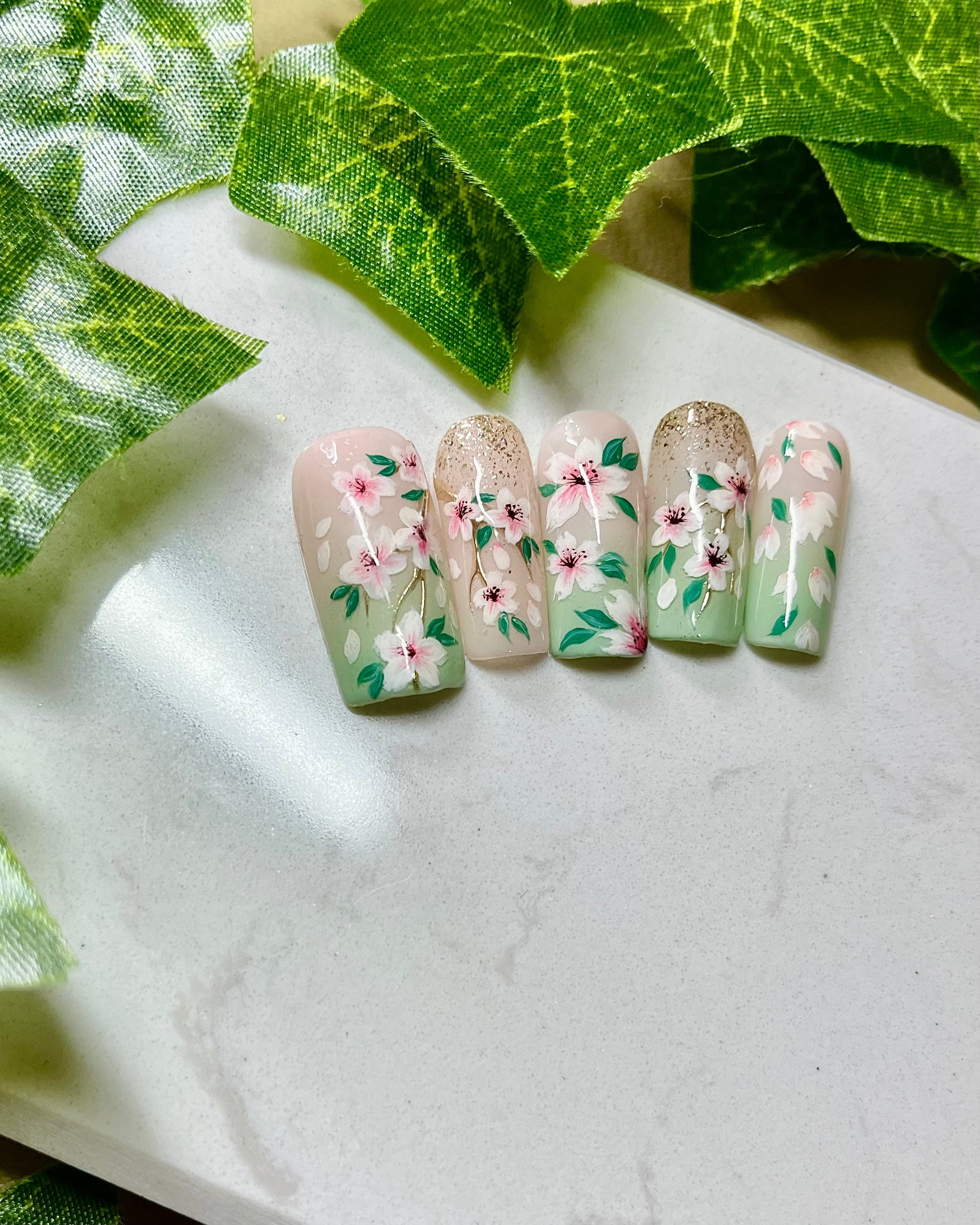 Handgemalte Press On Nägel mit kleinen Kirschblüten auf hellgrünem Hintergrund, wiederverwendbares Nagelset