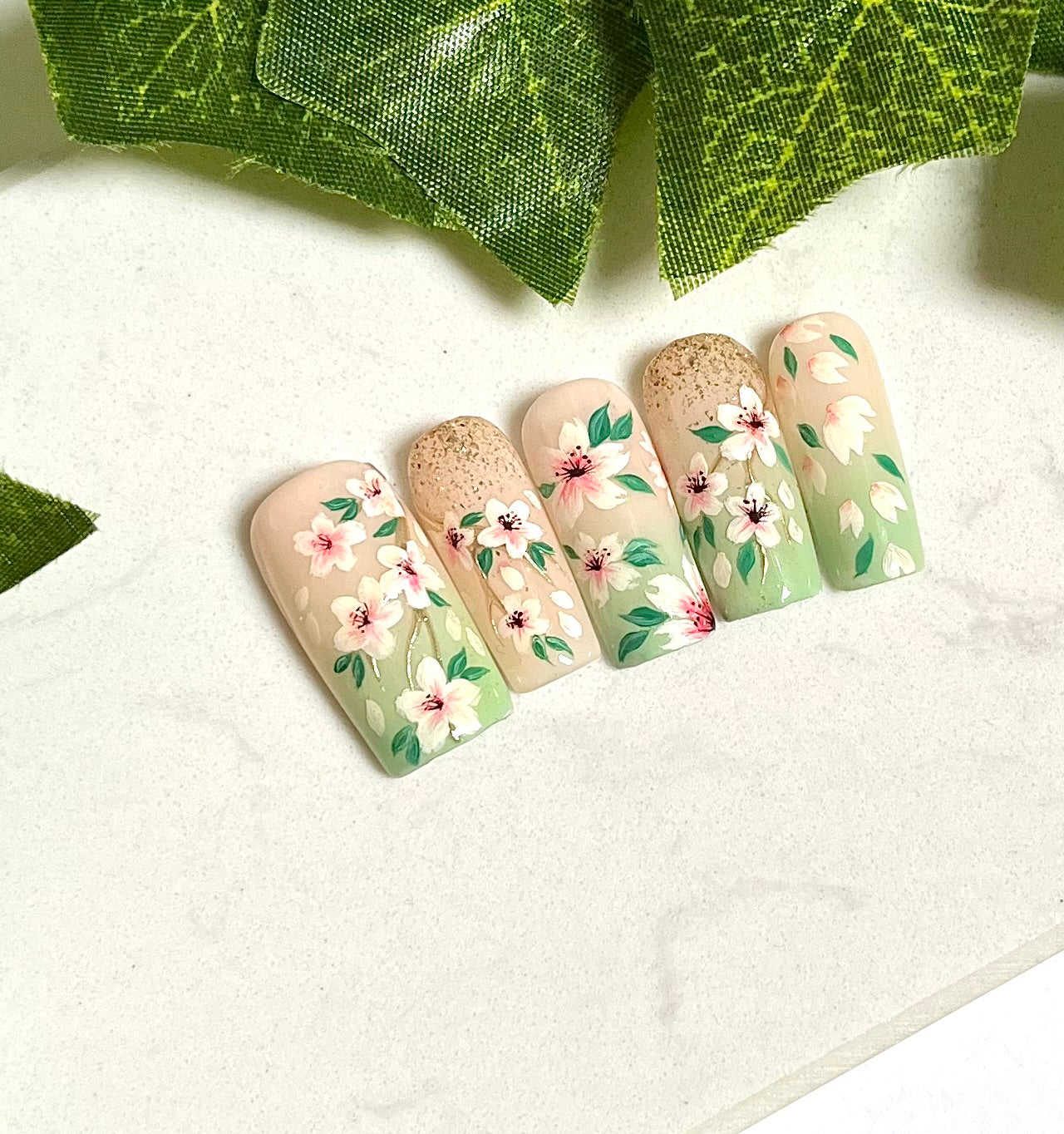 Handgemalte Press On Nägel mit kleinen Kirschblüten auf hellgrünem Hintergrund, wiederverwendbares Nagelset